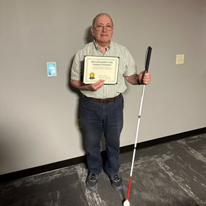A photo of Eugene holding his certificate smiling