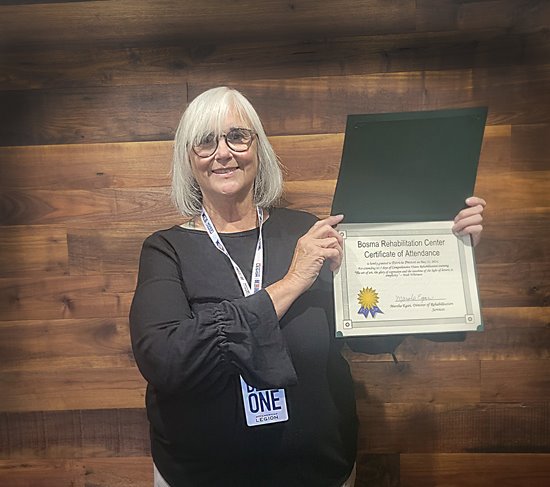 Patty Preston holds up her certificate of completion of Bosma's Rehabilitation Program