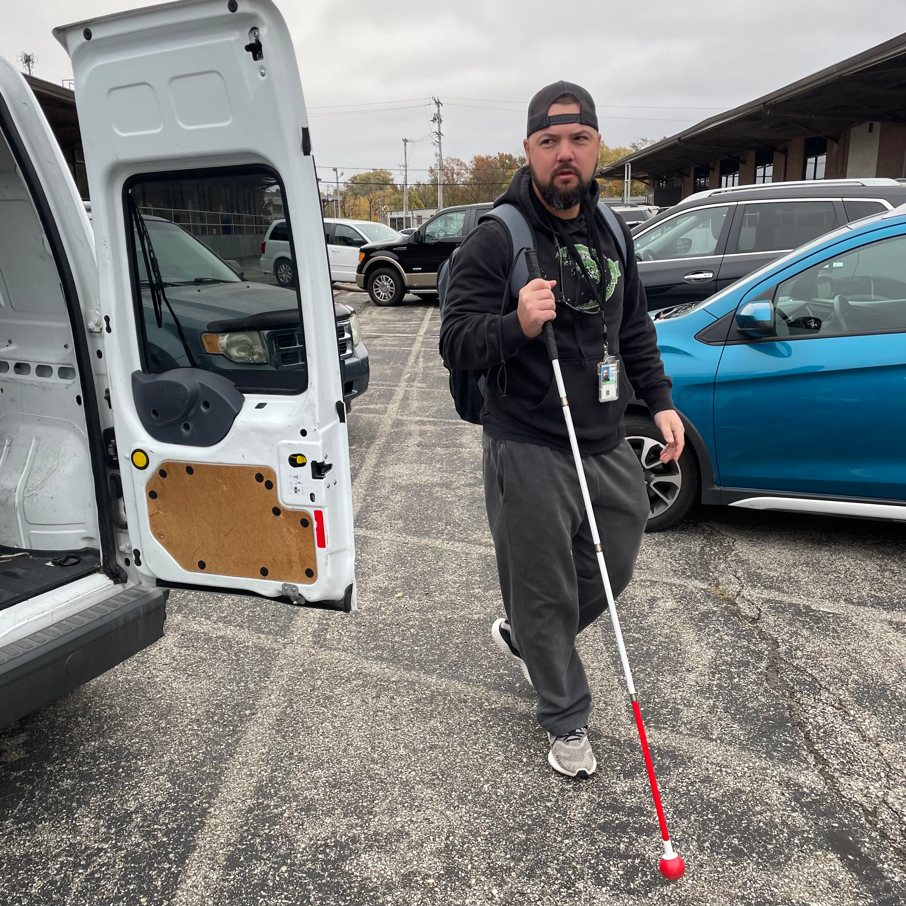 Blind man walking through a parking lot