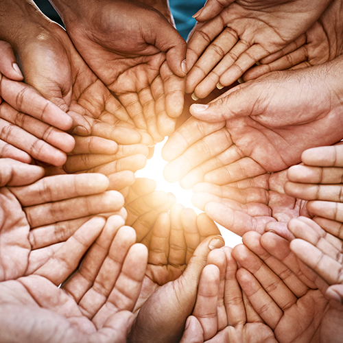 Open hands forming a circle with a bright light coming through the center.