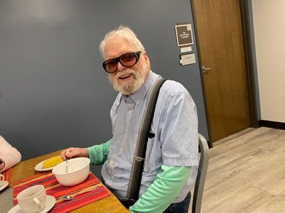 Richard sitting at the head of the table smiling on the day of his graduation from Bosma Rehabilitation 
