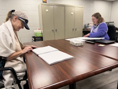 Client, Becky and Instructor, Amber pictured laughing during a Braille class.