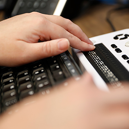 Closeup of hands using a Braille keyboard