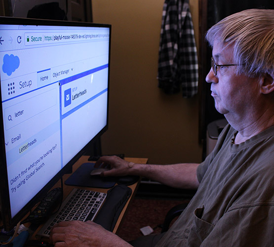 Man looking at a computer screen with enlarged text. 