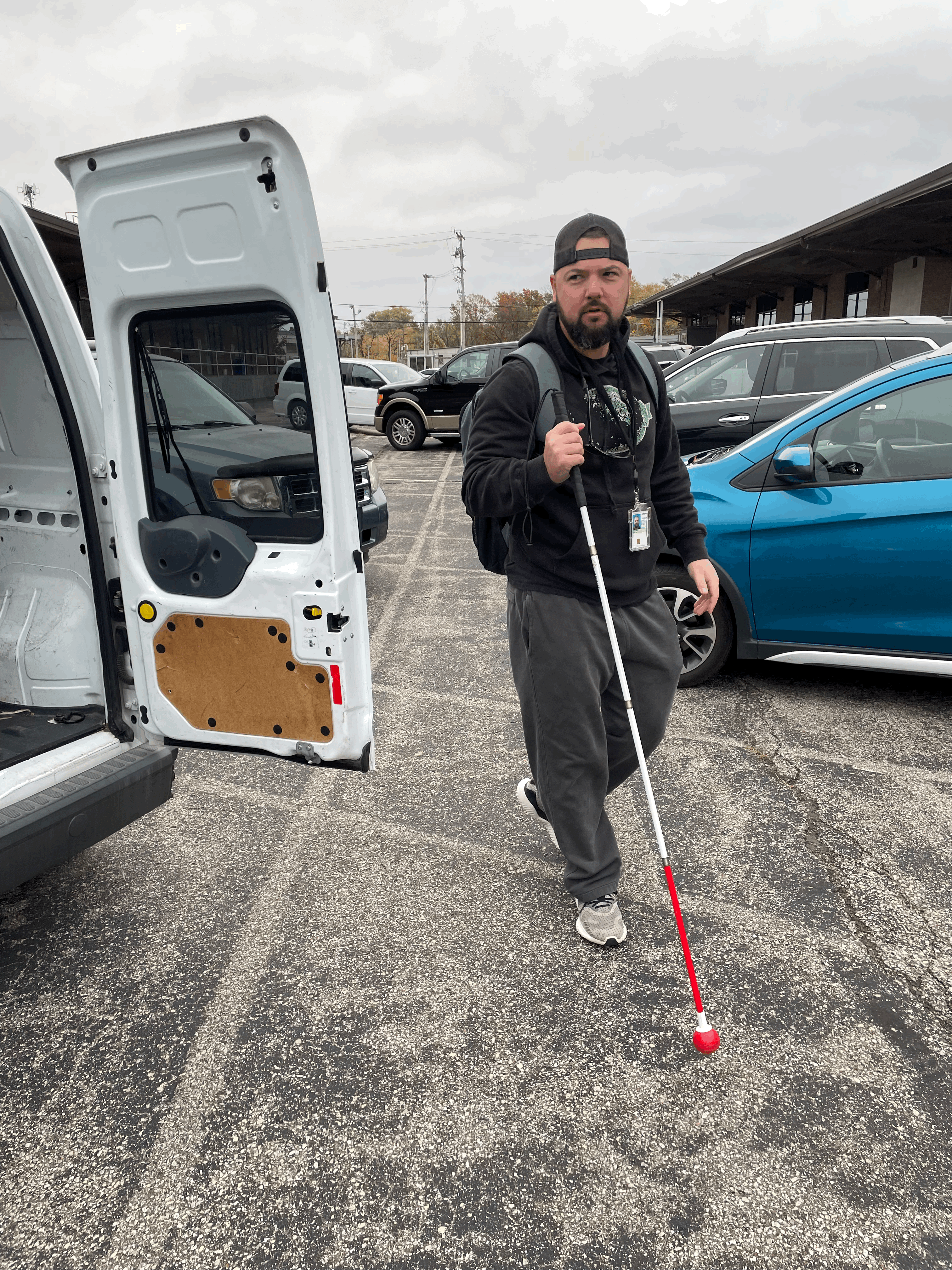 blind man walking through a parking lot