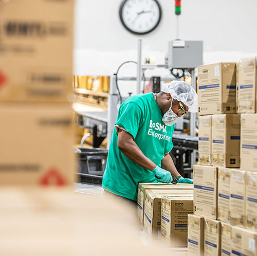 Workers on a line assembling medical kits