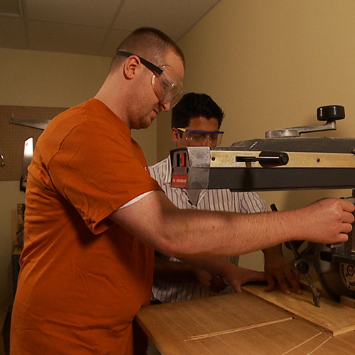 A man using a power saw. 