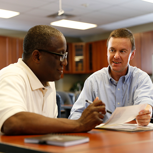 Two men checking over a paper