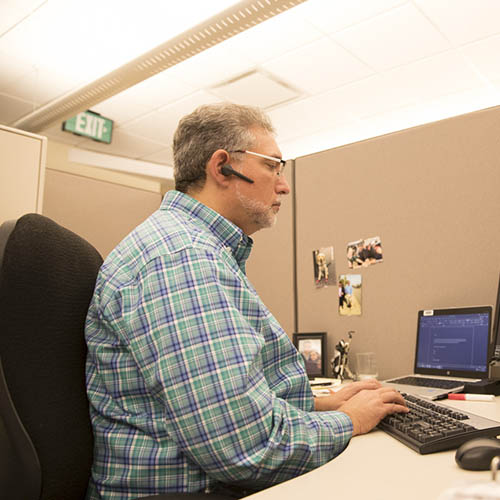 Mark sitting at a desk working at a computer.