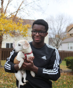 Dan Nanista holding dog while standing outside.