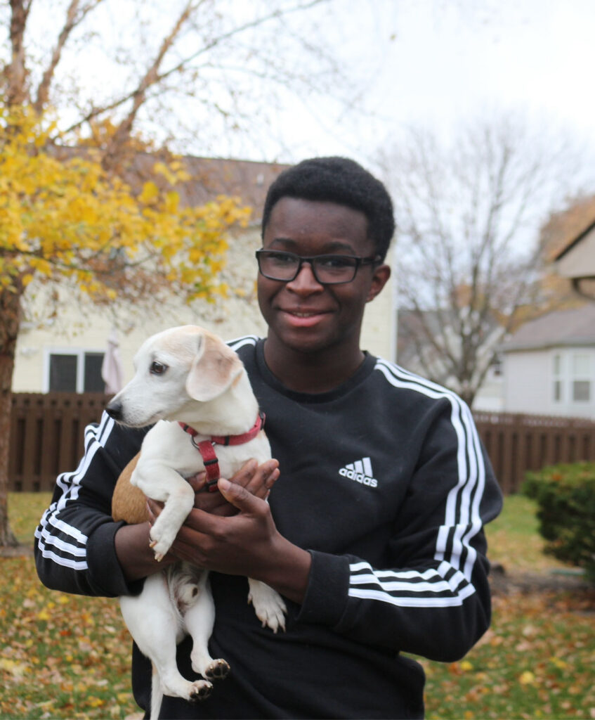 Dan Nanista holding dog while standing outside.