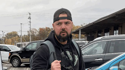Joel Taulbee walking in parking lot with white cane.