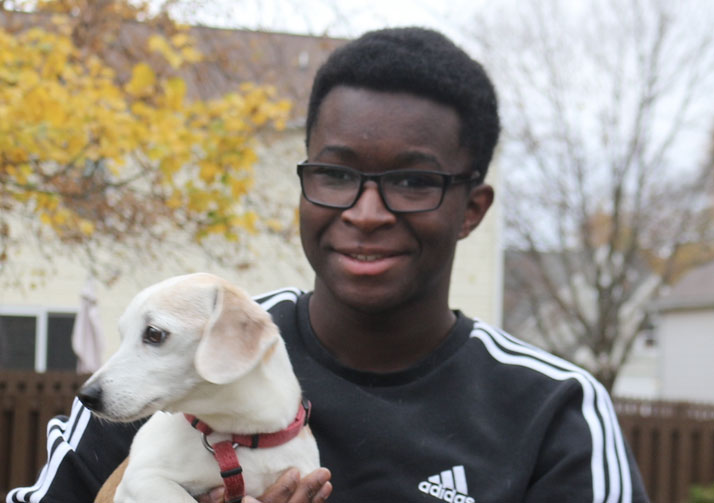 Dan Nanista holding dog while standing outside.