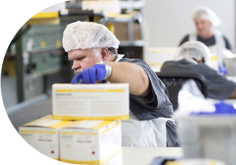 Bosma employee packing boxes on an assembly line.