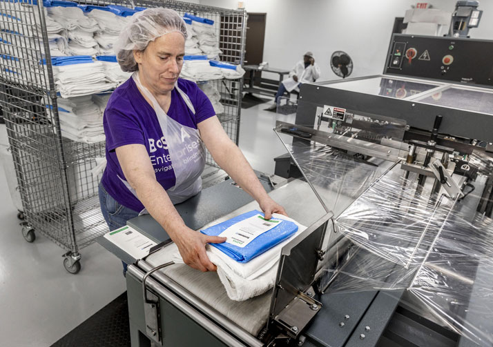 Bosma employee placing products into wrapping machine.
