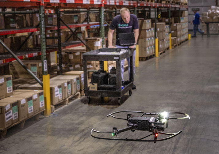 Bosma employee operating inventory management drone in warehouse.