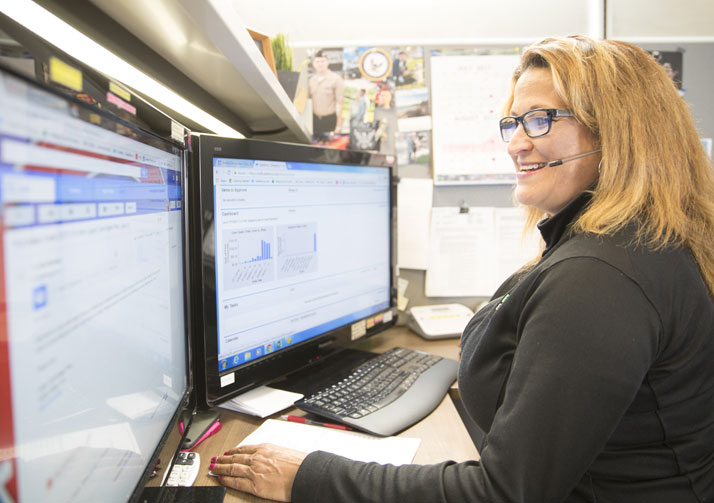 Bosma customer service rep talking on headset while working at a computer.