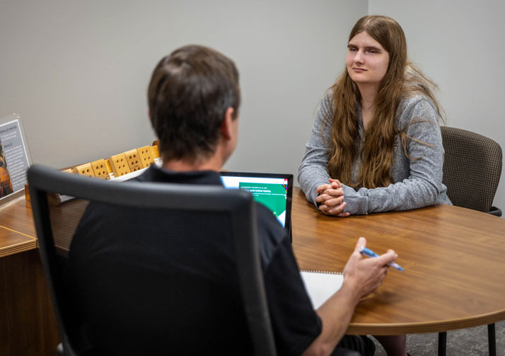 Bosma employee talking with young woman seated at a desk.