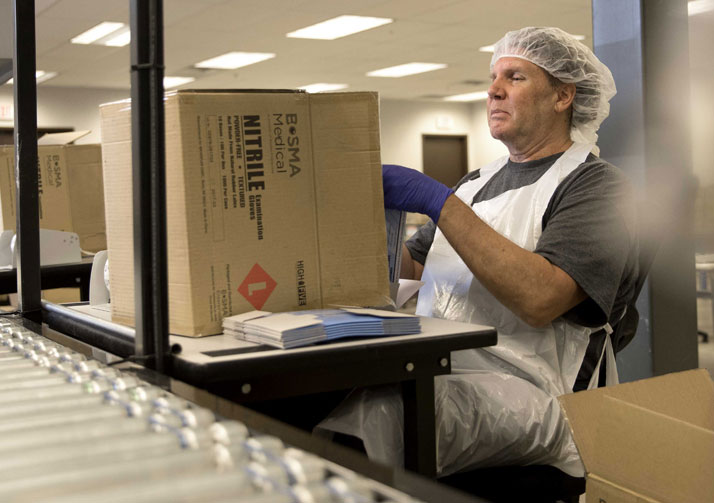 Bosma employee packing box on conveyor belt.