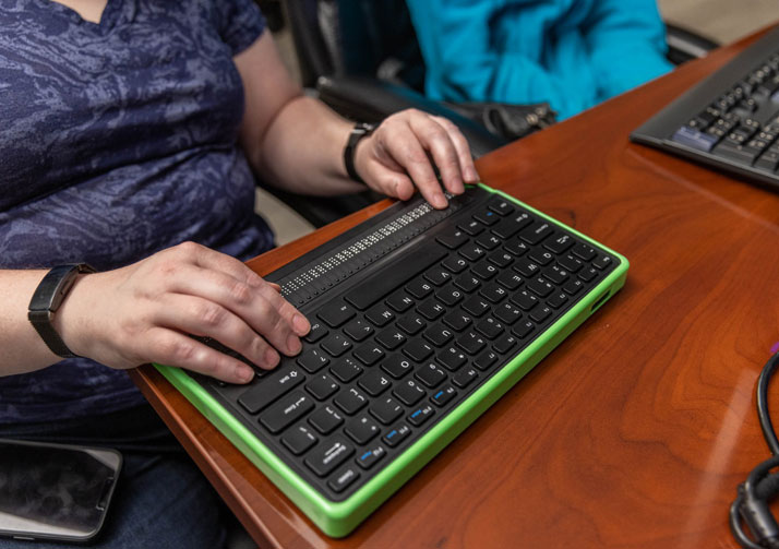 Close up photo of a woman's hands using a wireless keyboard.