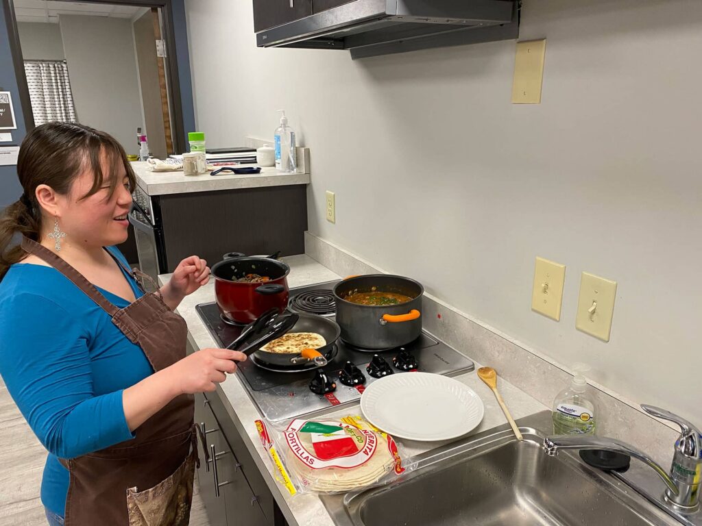 Karthryn cooking at a stove.